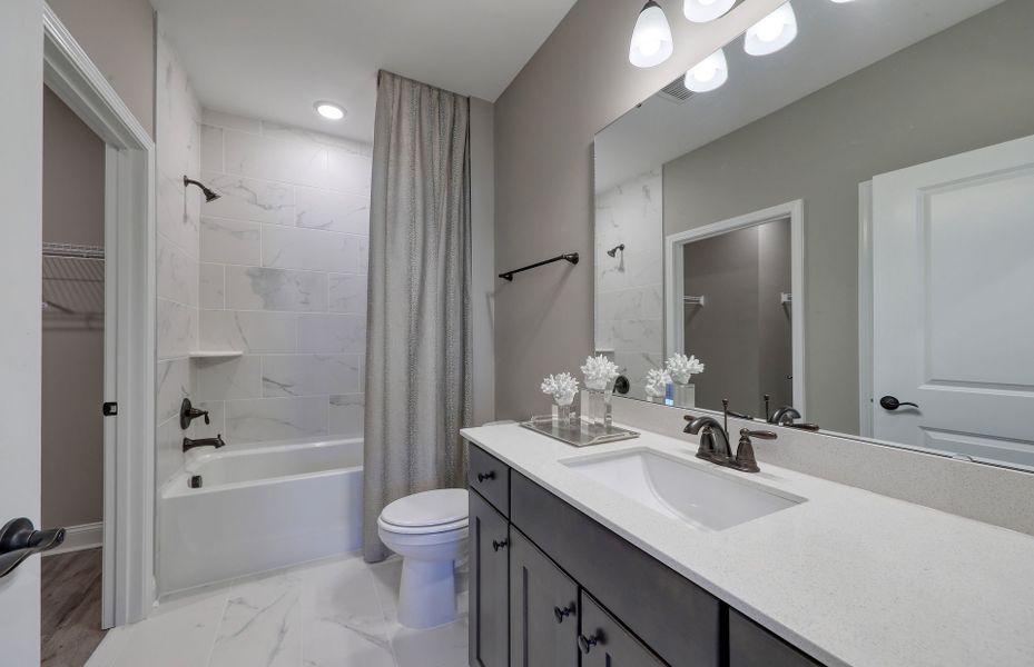 The secondary bathroom boasted sleek modern fixtures and a refreshing color palette.