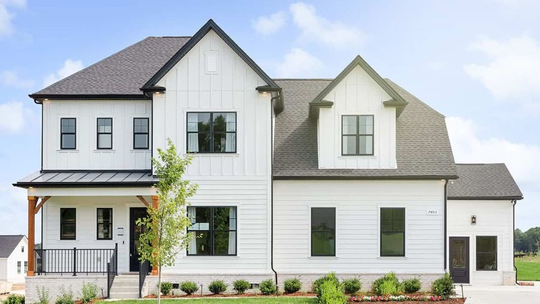Exterior of gorgeous model home with white siding and black accents and windows Exterior of gorgeous model home with white siding and black accents and windows