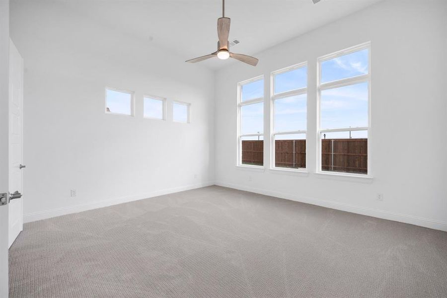 Carpeted spare room featuring ceiling fan