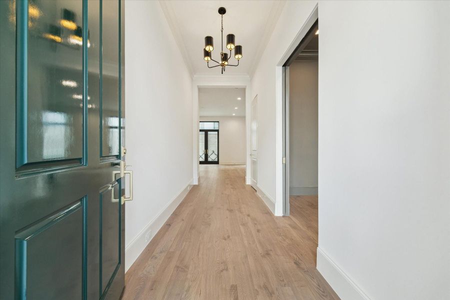 Step into this bright and welcoming formal entry. The first floor living space features 11-foot ceilings, Legno Bastone engineered White Oak wood floors in the color Gavi, and designer light fixtures.