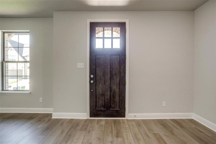 Foyer featuring light wood finished floors and baseboards
