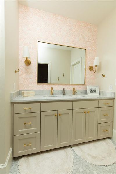 Full bathroom with double vanity and baseboards