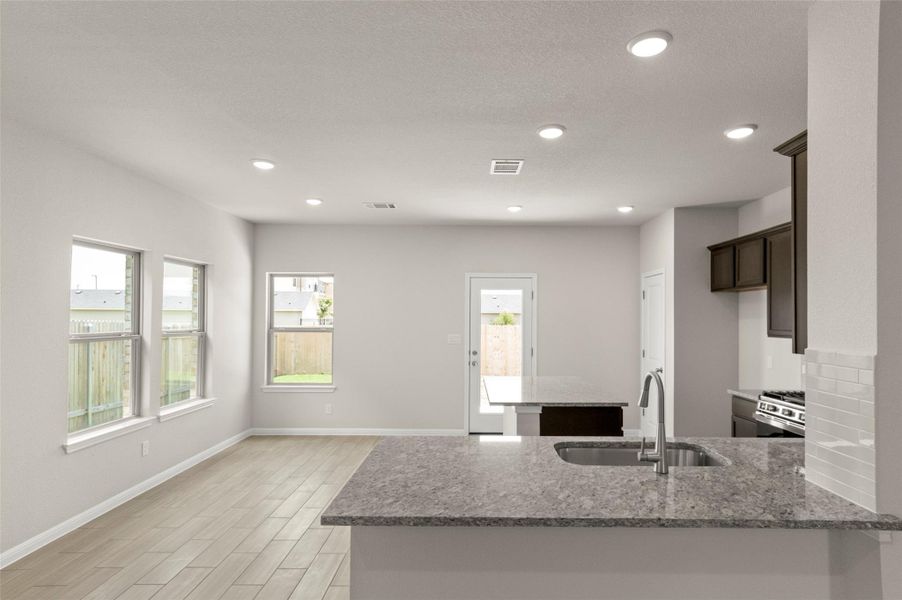 Kitchen featuring stainless steel range with gas cooktop, light stone counters, plenty of natural light, and recessed lighting