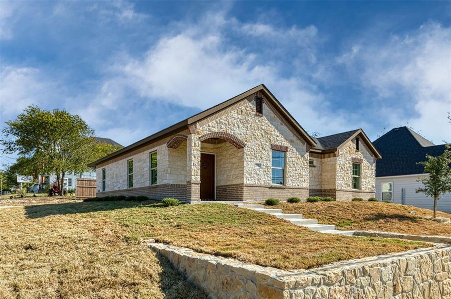 French country style house featuring stone siding and a front lawn French country style house featuring stone siding and a front lawn