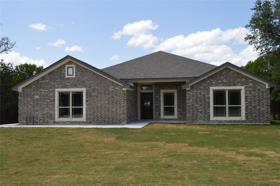 View of front of property with brick siding and a front lawn