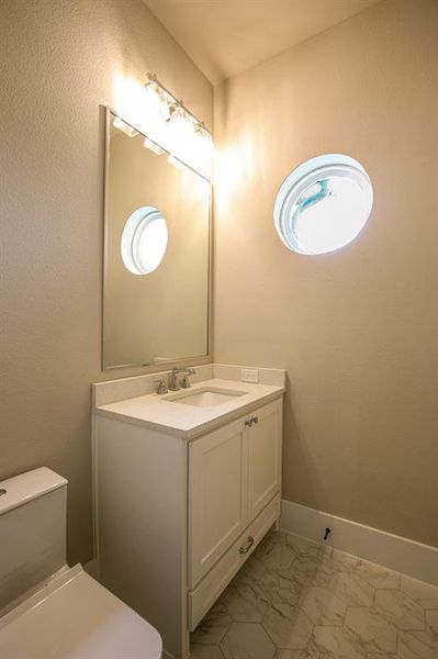 Bathroom with tile patterned floors, vanity, and toilet