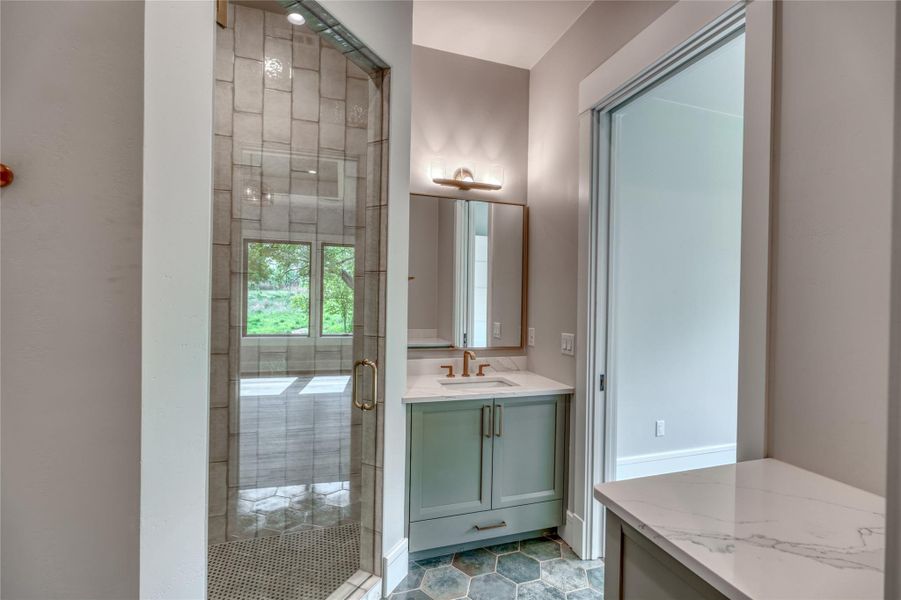 Full bath with a shower stall and vanity
