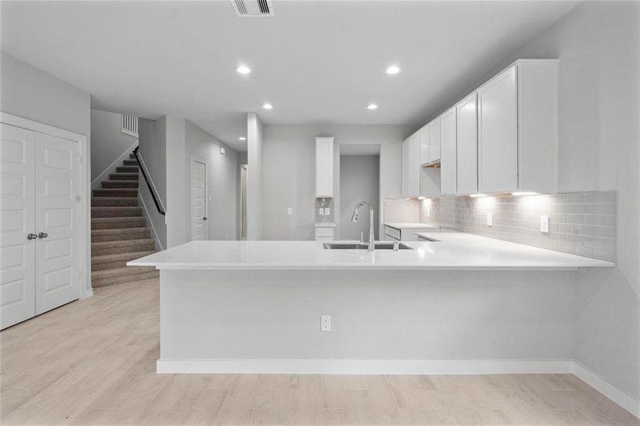 This kitchen is by far any chef’s dream! This spacious kitchen features high ceilings, stained wood cabinets, quartz countertops, SS appliances, modern tile backsplash, recessed lighting, extended counter space for breakfast bar, and a walk-in pantry all overlooking your huge family room.