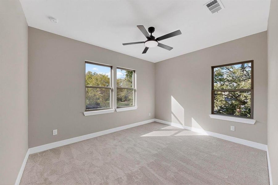 Spare room featuring light carpet and ceiling fan