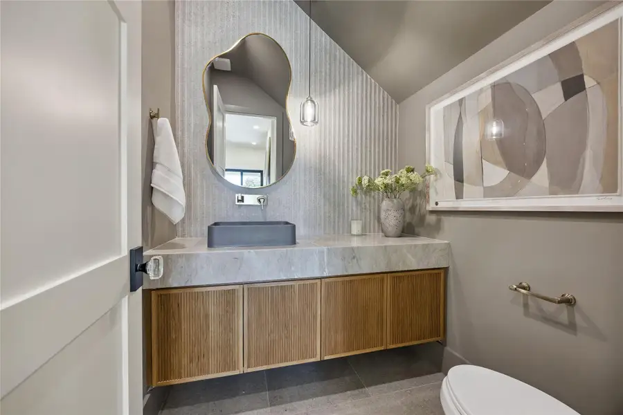 HALF BATH: Zen-inspired powder bath showcasing a gray concrete vessel sink, elegant wall-mounted faucet, textured wallcovering, and custom stone finishes including Mont Blanc Gold Quartzite.