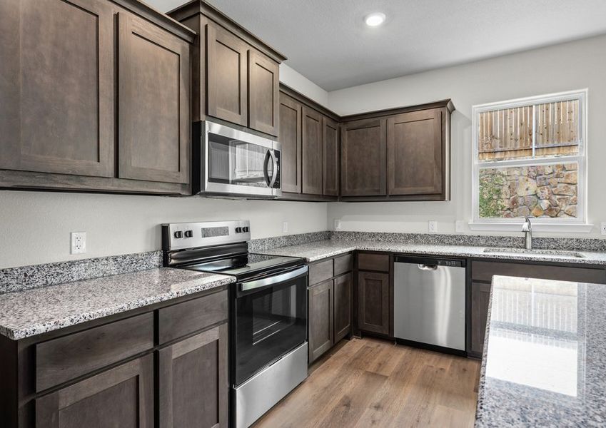 The kitchen has beautiful wood cabinetry.