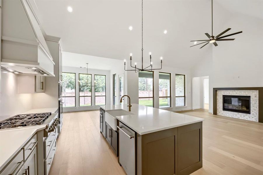 Open-concept living space featuring vaulted ceilings, light wood-finish flooring, and abundant natural light from multiple windows Open-concept living space featuring vaulted ceilings, light wood-finish flooring, and abundant natural light from multiple windows