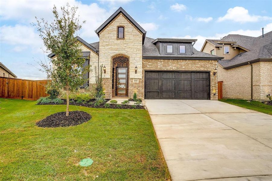 View of front of house featuring a garage and a front lawn