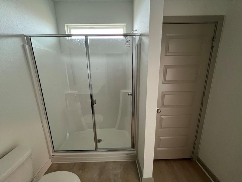 Full bathroom with a stall shower and light wood-style flooring Full bathroom with a stall shower and light wood-style flooring