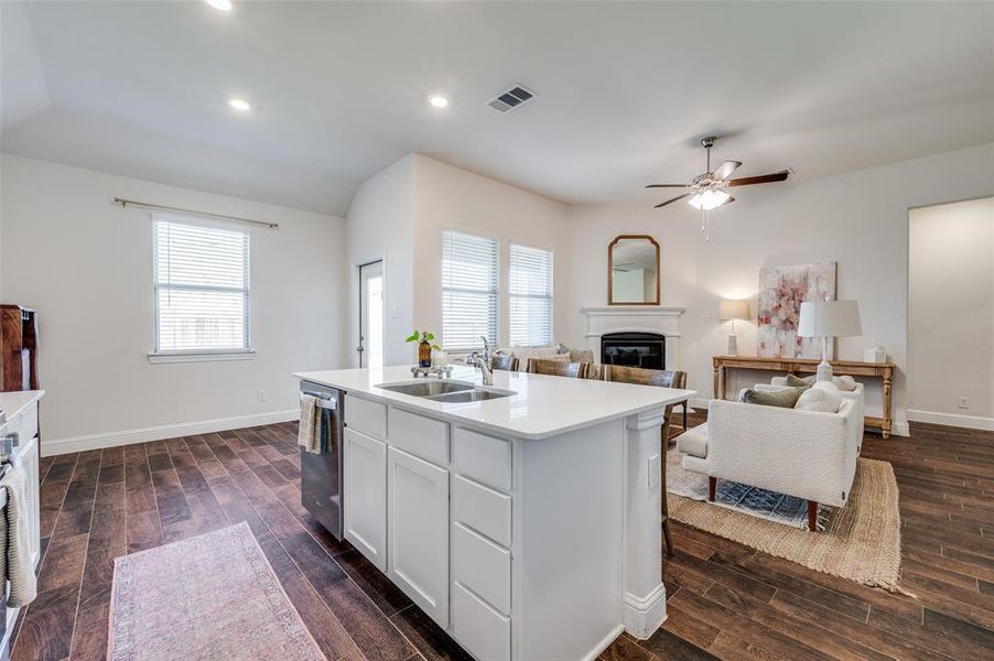 Kitchen featuring an island with sink, stainless steel dishwasher, a healthy amount of sunlight, and sink