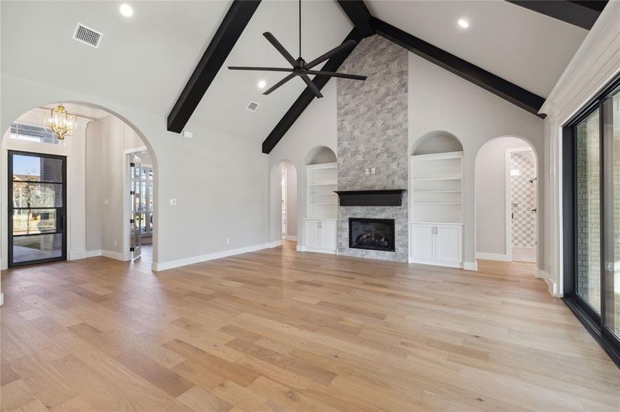 Unfurnished living room with a fireplace, plenty of natural light, and high vaulted ceiling