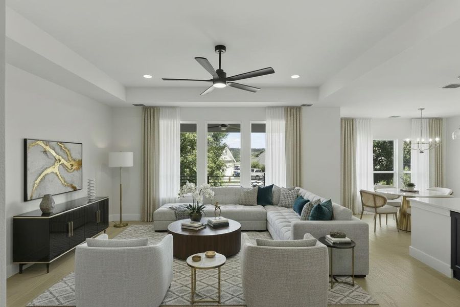 Open-concept living space with light wood-finish flooring, recessed lighting, and a modern ceiling fan Open-concept living space with light wood-finish flooring, recessed lighting, and a modern ceiling fan