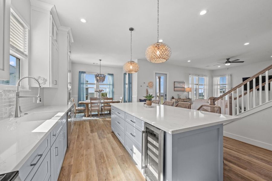 From this angle, you can admire the seamless flow towards the dining area. Take note of the built-in wine fridge and the generous storage space within the island.