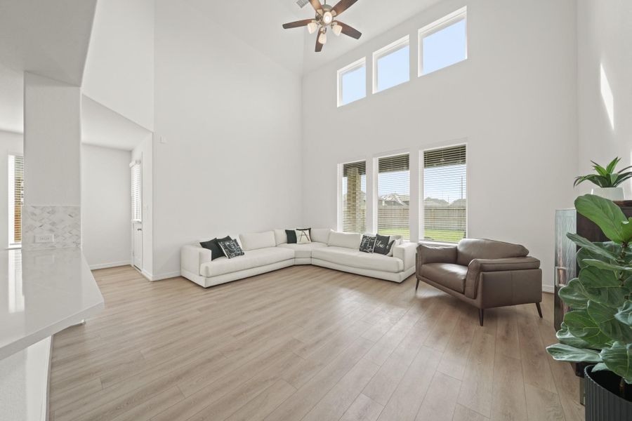 This expansive living room features high ceilings, large windows for natural light, and modern flooring. Ideal for comfortable living and entertaining.