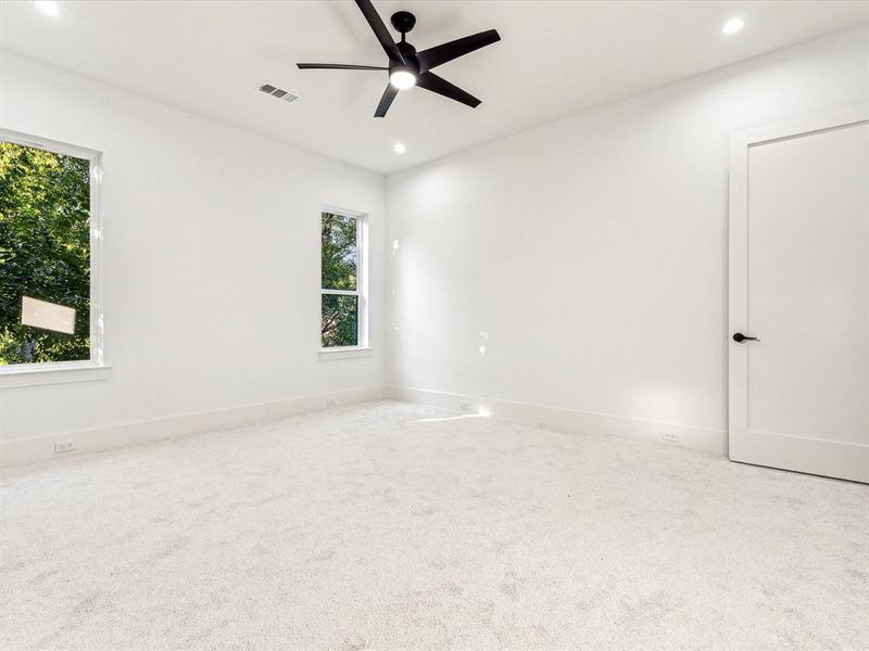 Carpeted empty room featuring ceiling fan