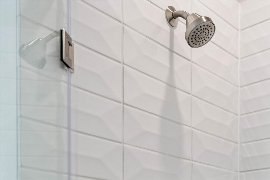 View of the primary bathroom walk-in shower and the gorgeous tile surround.