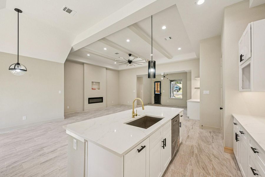 This photo showcases a modern, open-concept living space  The adjacent living area has high ceilings, recessed lighting, and a built-in fireplace, creating a bright and inviting atmosphere.