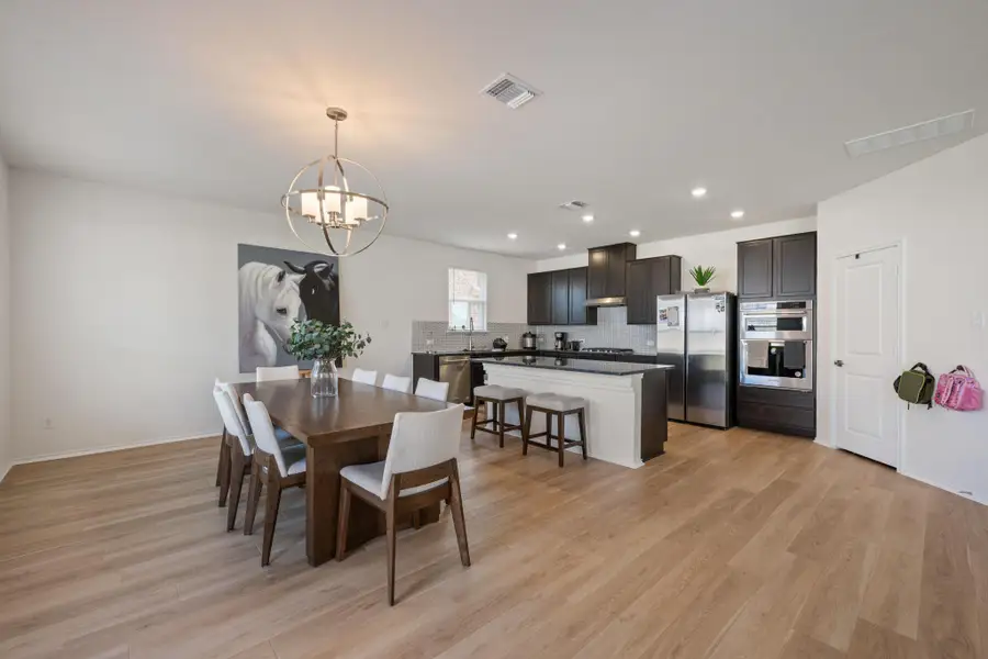 Dining room featuring light wood finished floors, recessed lighting, and a chandelier Dining room featuring light wood finished floors, recessed lighting, and a chandelier
