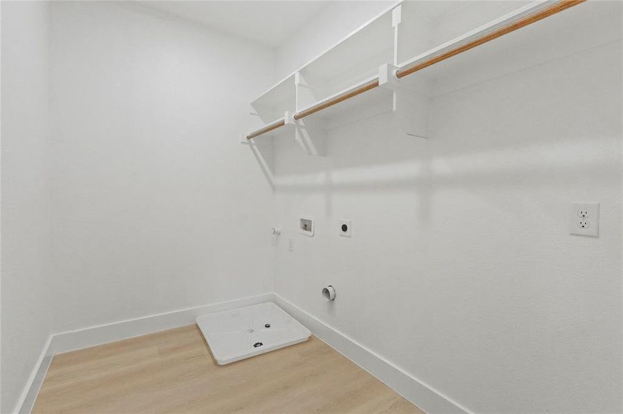 Washroom with light wood-style flooring, gas dryer hookup, electric dryer hookup, and hookup for a washing machine Washroom with light wood-style flooring, gas dryer hookup, electric dryer hookup, and hookup for a washing machine