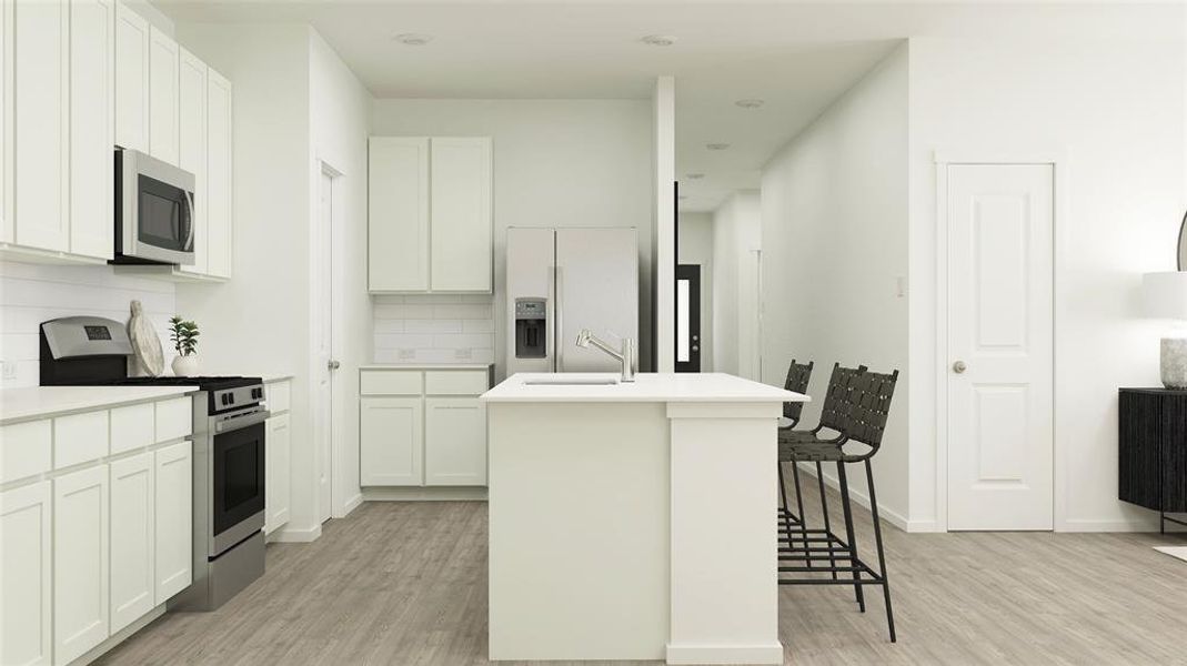 Kitchen featuring appliances with stainless steel finishes, white cabinetry, sink, decorative backsplash, and a center island with sink