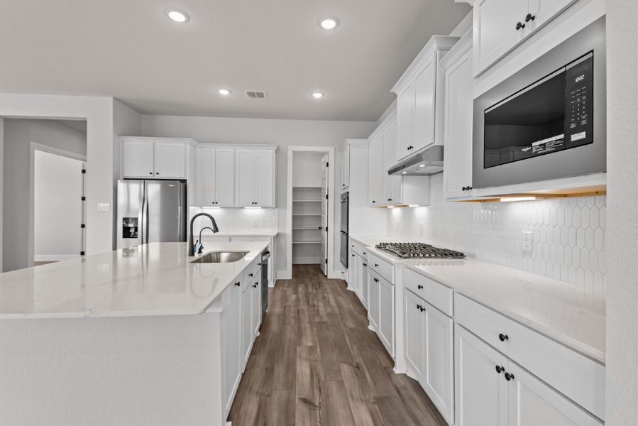 A kitchen with white cabinets.