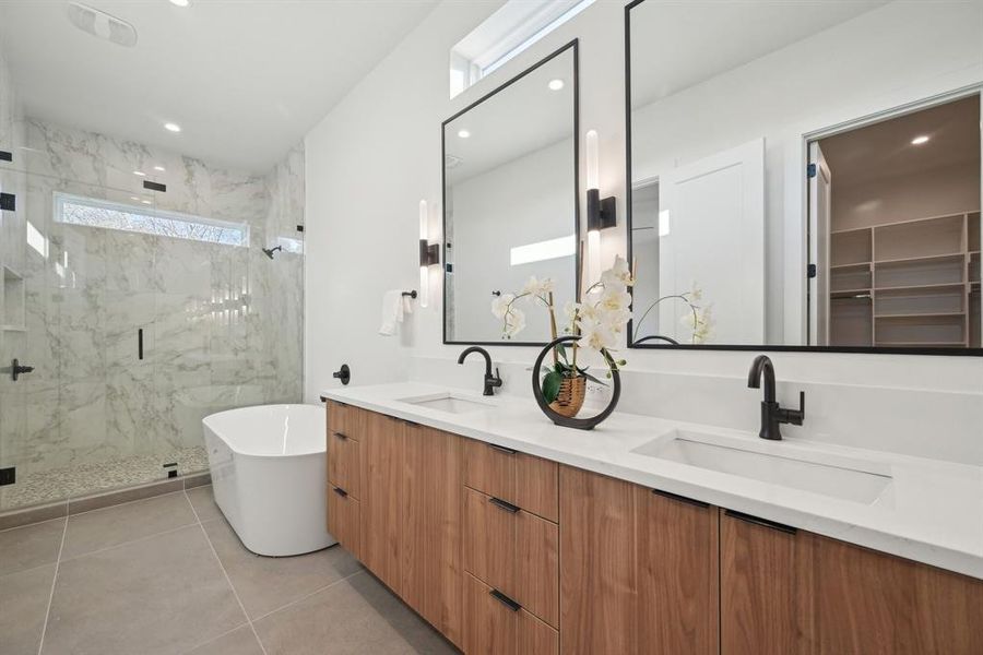 Bathroom featuring vanity, tile patterned flooring, and shower with separate bathtub