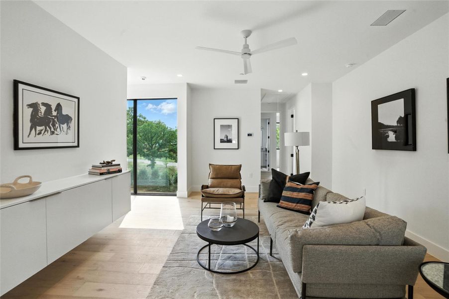 Living area featuring light wood finished floors, recessed lighting, and ceiling fan Living area featuring light wood finished floors, recessed lighting, and ceiling fan