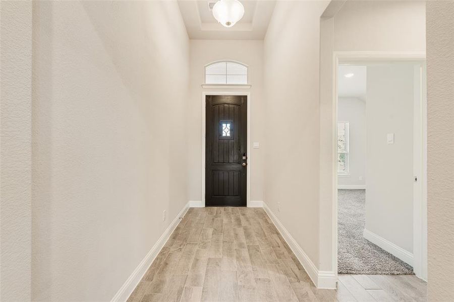 Foyer featuring light wood-type flooring and baseboards