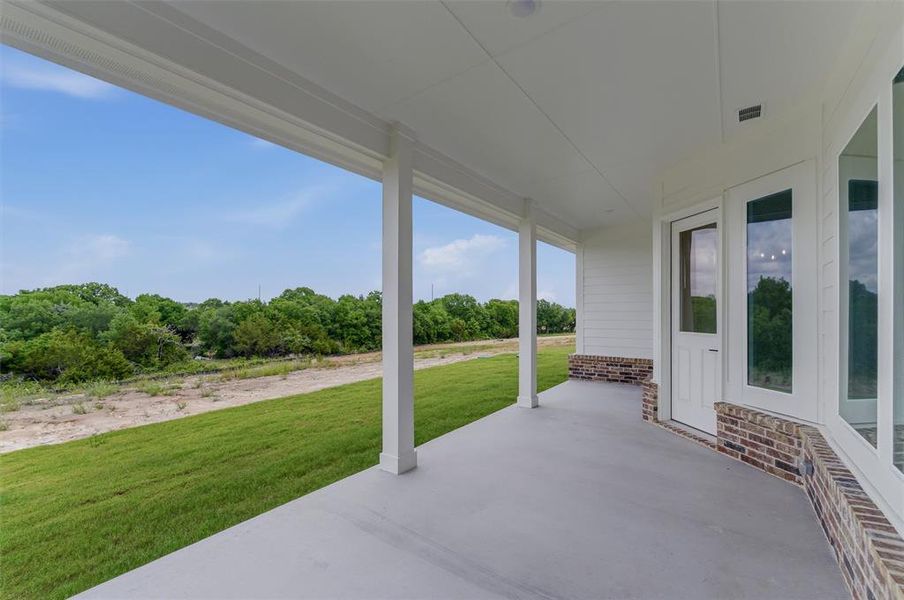 Expansive covered patio featuring a concrete surface and white support columns