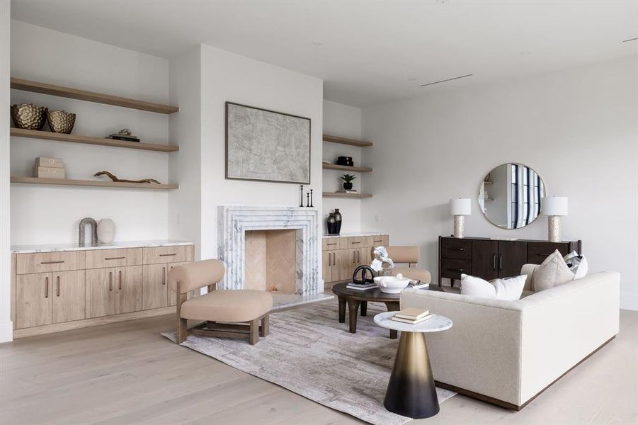 Living area with light wood-style floors and a premium fireplace