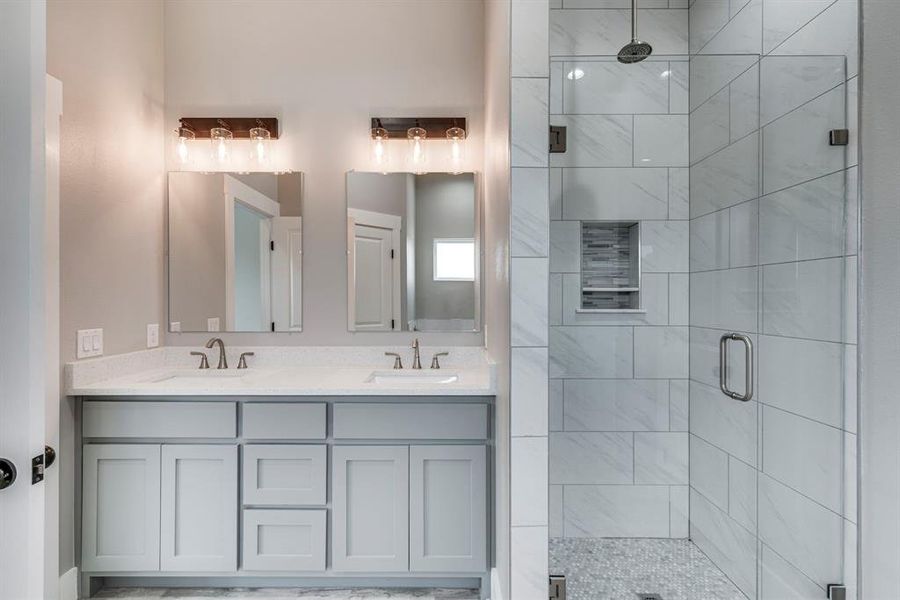 Bathroom featuring double vanity and an enclosed shower