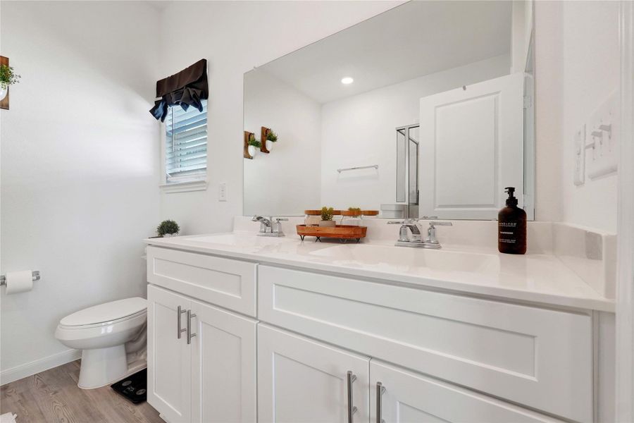 Enjoy a touch of luxury in the private en-suite bathroom, featuring dual vanities, a soaking tub, and a separate walk-in shower—your personal space to unwind and rejuvenate.