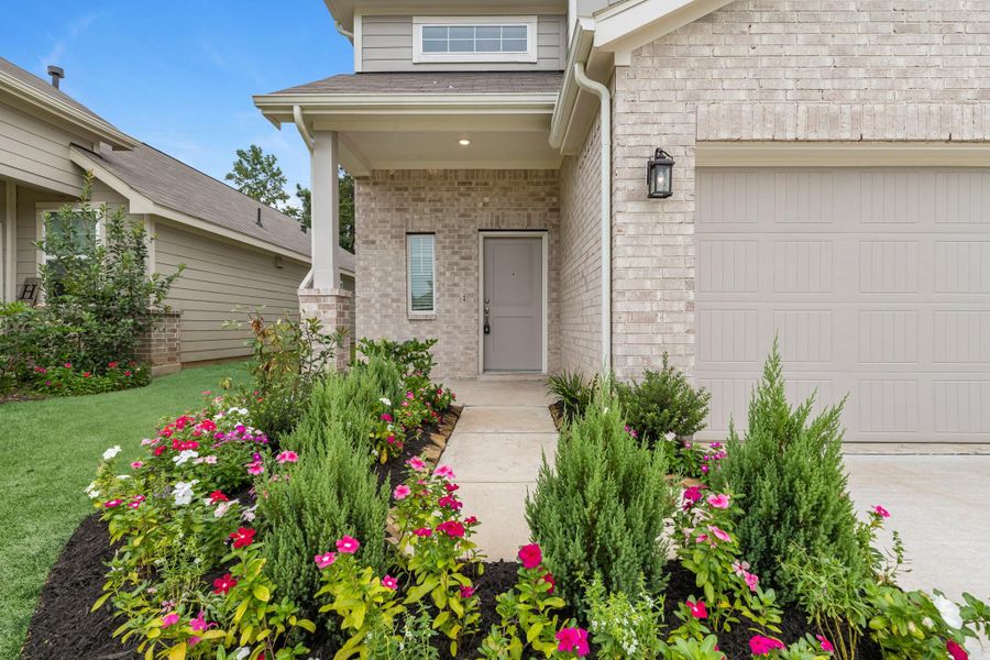 Charming front elevation featuring a beautifully maintained garden, lush landscaping, and inviting curb appeal that sets the tone for the rest of the home.