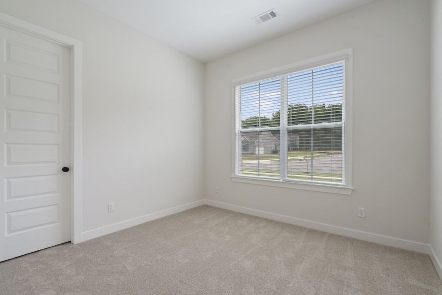 Neutral toned walls and carpeting with a multi-pane window