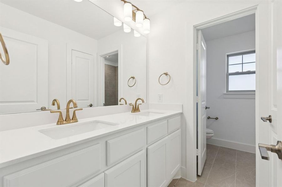 Full bathroom with double vanity and light tile patterned floors
