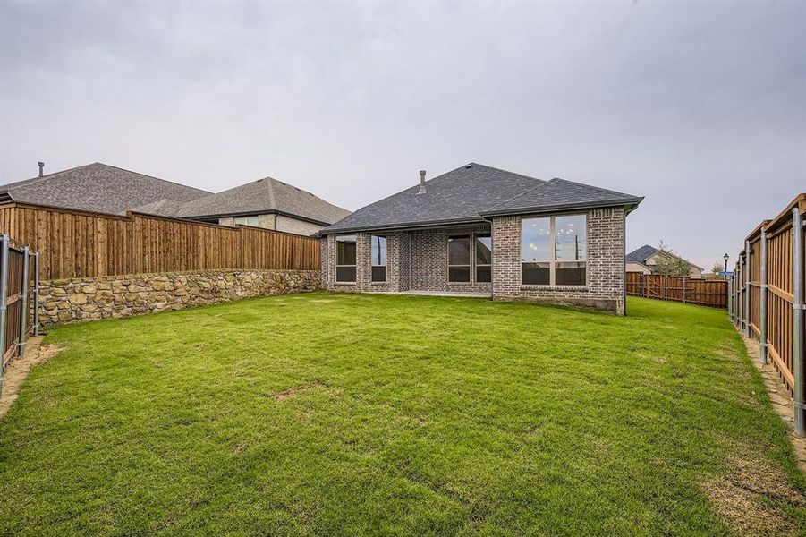 Back of property featuring roof with shingles, a fenced backyard, a patio, and brick siding