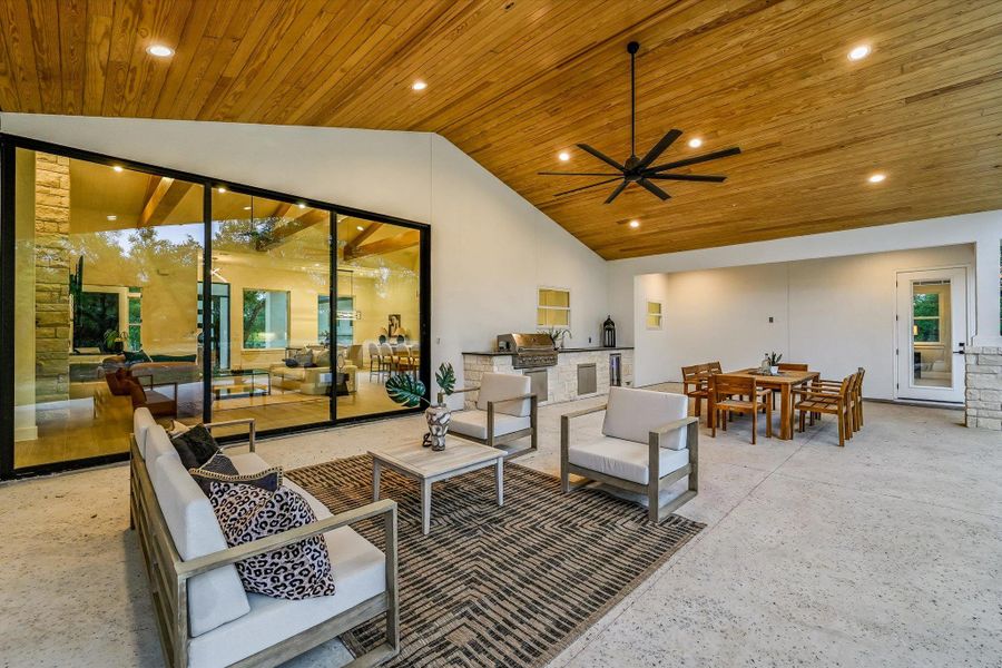 View of patio with an outdoor living / dining area, an outdoor kitchen, and ceiling fan