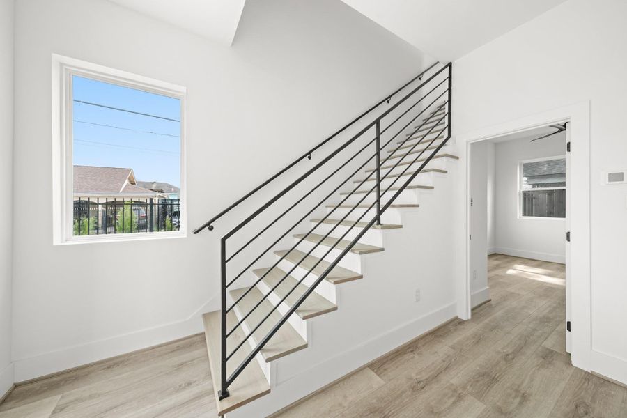 The first floor stairwell features elegant wood treads and leads directly to the third bedroom on the right. The first floor stairwell features elegant wood treads and leads directly to the third bedroom on the right.