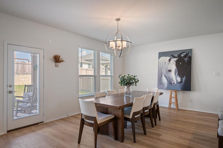 Dining area featuring light wood-style flooring and hanging lights