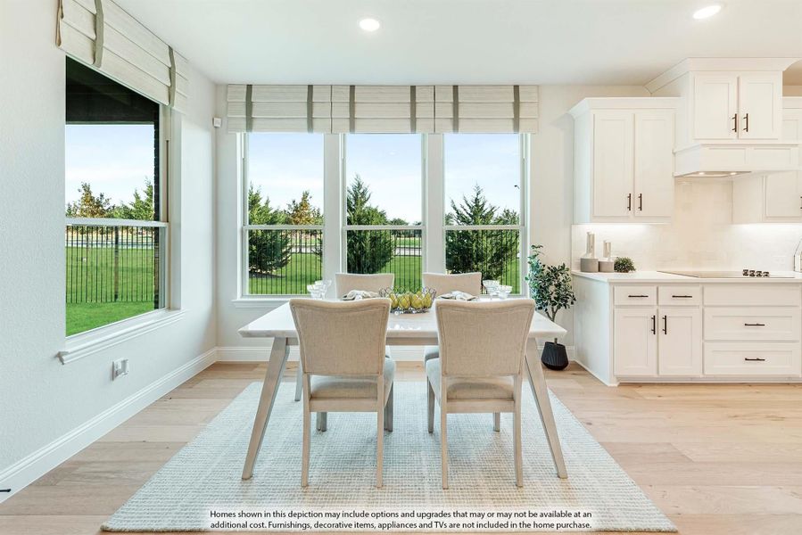Bright dining area with white table, neutral chairs, large windows, and light hardwood floors adjacent to white kitchen cabinets.
