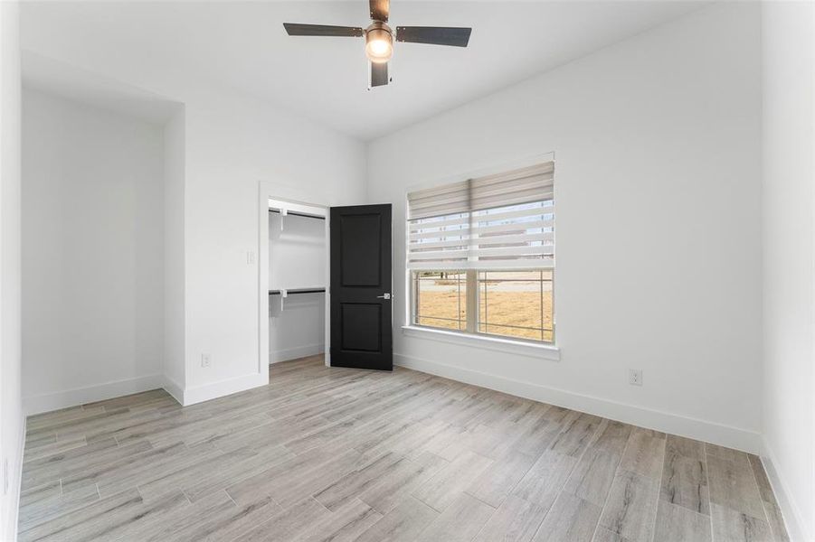 Unfurnished bedroom featuring a closet, light hardwood / wood-style flooring, and ceiling fan