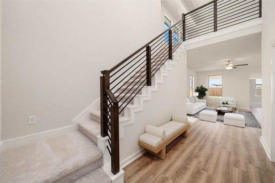 A bright and welcoming entryway featuring clean lines, modern railing details, and natural light that sets the tone for the home’s contemporary style. A bright and welcoming entryway featuring clean lines, modern railing details, and natural light that sets the tone for the home’s contemporary style.