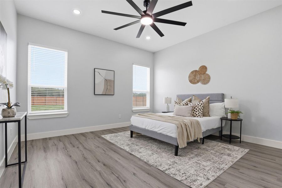 Spacious room with wood-finish flooring, two windows with blinds, recessed lighting, and a modern ceiling fan