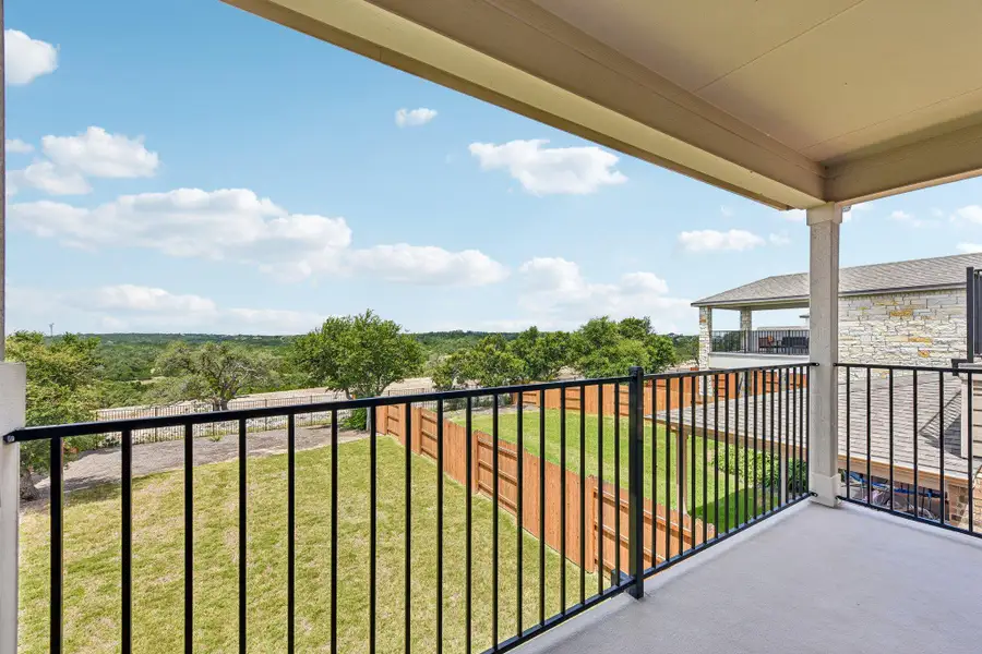 Perched above a private yard, a generous covered balcony offers serene views of the surrounding landscape.