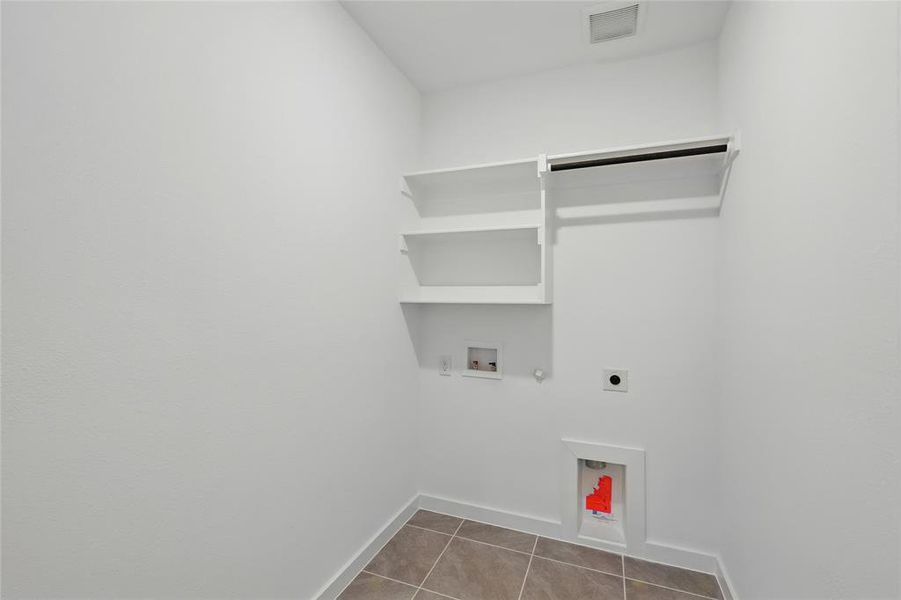 Laundry area featuring gas dryer hookup, electric dryer hookup, washer hookup, and light tile patterned floors